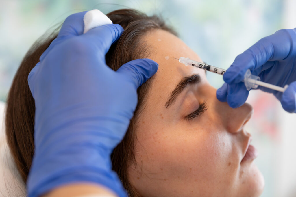 A provider injects Dysport near Waukee, IA, into a patient's forehead.