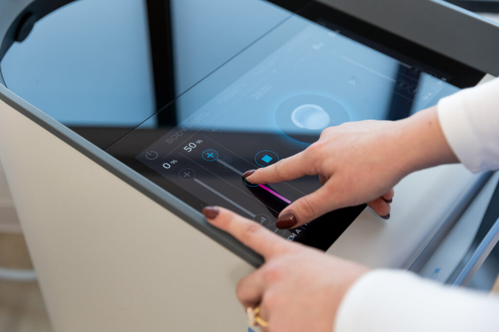 A provider adjusts the settings on an Emsella device for a patient's urinary incontinence treatment in Des Moines.