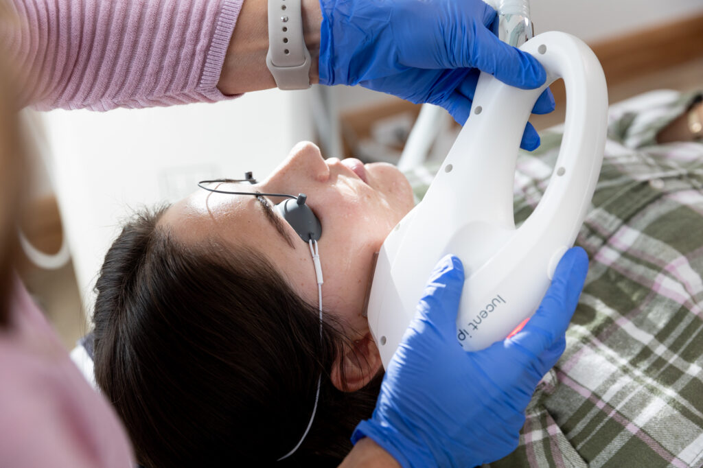 A provider presses the device for intense pulsed light in Des Moines against a patient's skin.
