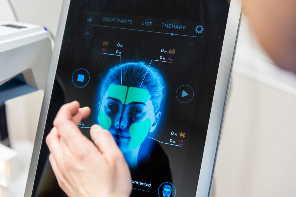 Close up of the digital control screen for Emface near Waukee, IA. The screen displays an anatomical guide of a face to enhance contouring results.